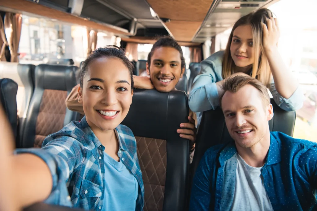 selective-focus-of-smiling-asian-woman-taking-selfie on a charter bus rental of epic tours